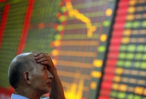 A stock investor reacts near a board displaying stock prices at a brokerage house in Huaibei in central China's Anhui province Monday June 24, 2013. Global stock markets reeled Monday, with Shanghai's index enduring its biggest loss in four years, after China allowed commercial lending rates to soar in a move analysts said was aimed at curbing a booming underground lending industry. (AP Photo) CHINA OUT